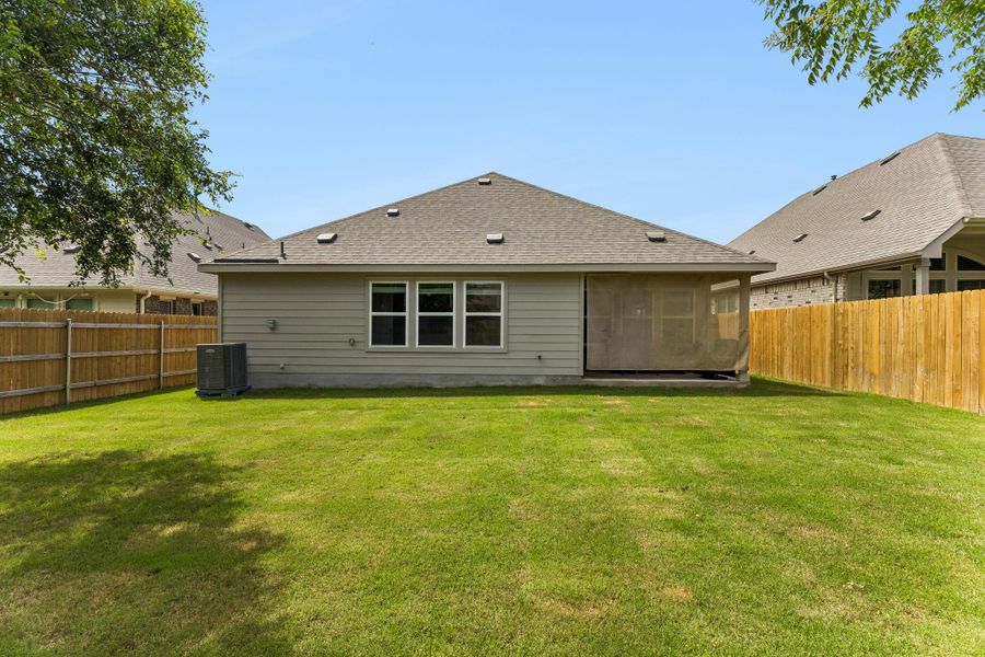 Expansive grass yard bordered by a wood privacy fence