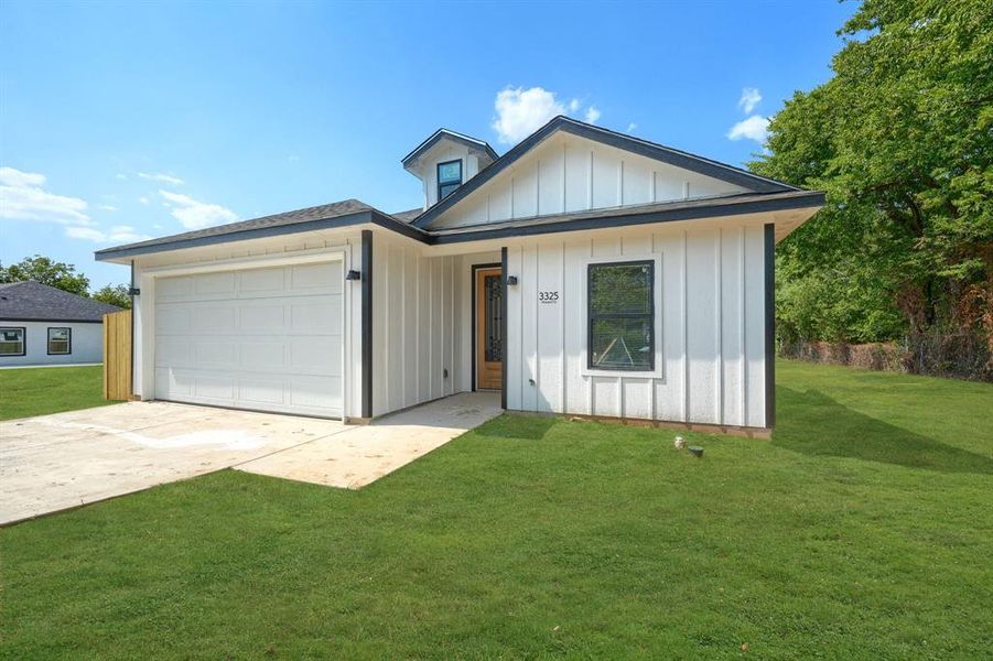 View of front facade with a garage and a front lawn