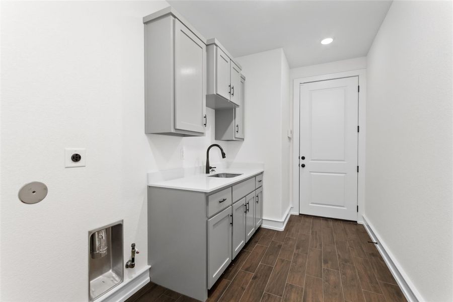 Laundry area featuring hookup for an electric dryer, cabinet space, dark wood-style flooring, baseboards, and recessed lighting Laundry area featuring hookup for an electric dryer, cabinet space, dark wood-style flooring, baseboards, and recessed lighting