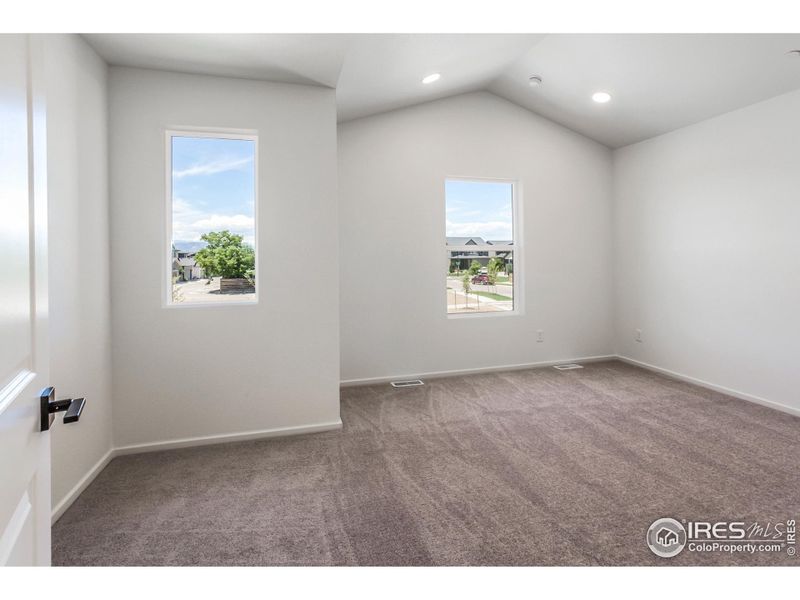 Spacious Primary with vaulted ceilings and natural light!