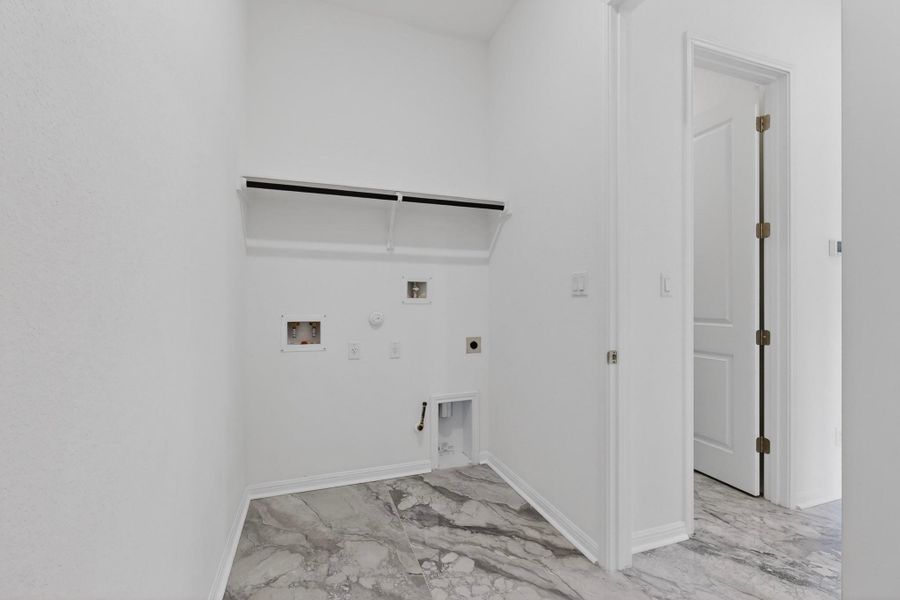 Utility area with marble-look tile flooring