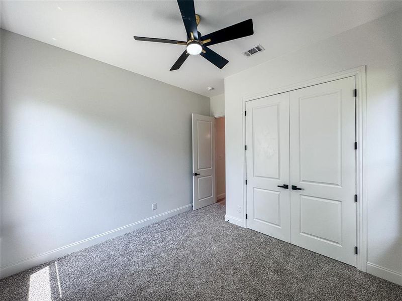 Unfurnished bedroom with carpet flooring, baseboards, a closet, and ceiling fan Unfurnished bedroom with carpet flooring, baseboards, a closet, and ceiling fan