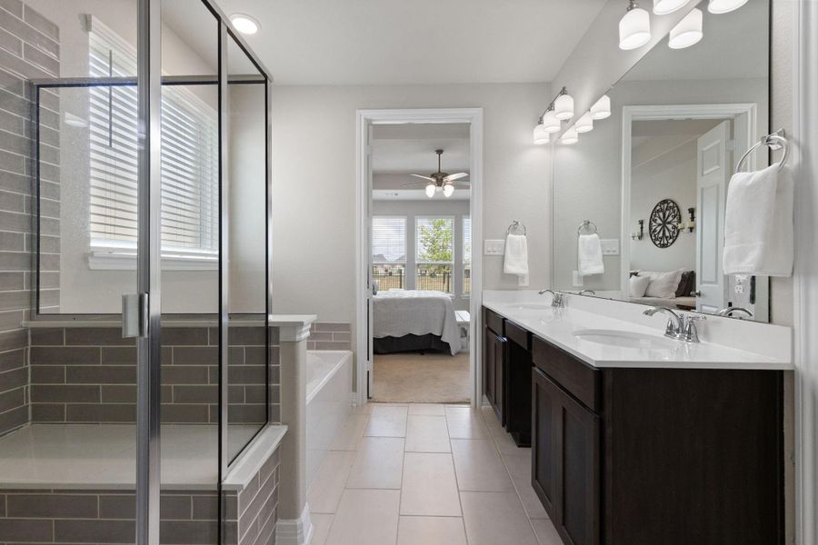 Primary ensuite with dual vanities, a soaking tub and separate shower.