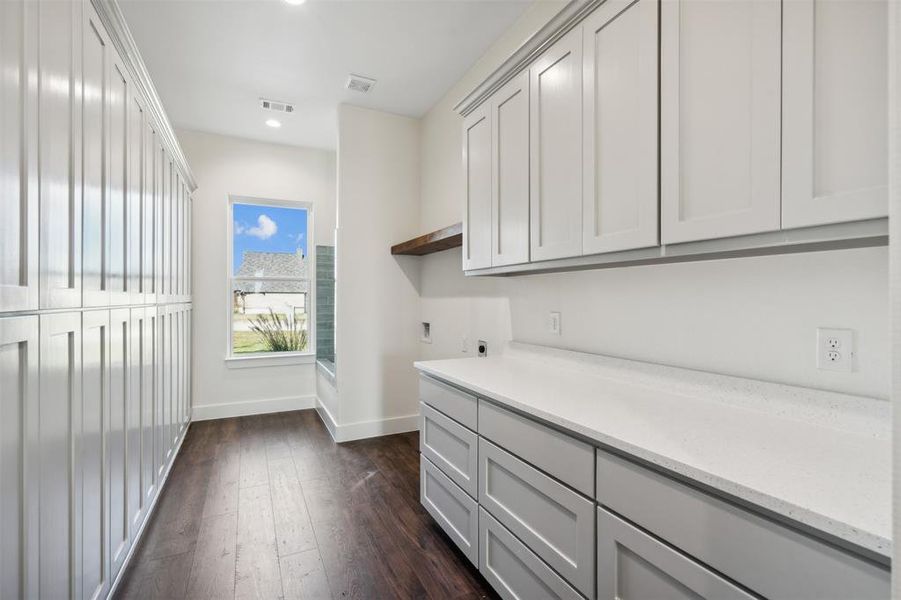 Laundry room with cabinets, dark hardwood / wood-style floors, and electric dryer hookup