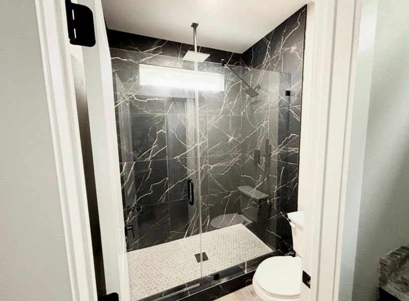 Primary bath with walk-in shower and  upgraded surround.