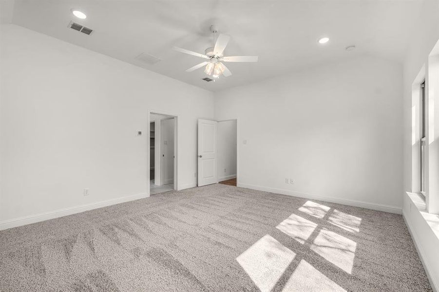 Unfurnished bedroom with light colored carpet, a ceiling fan, recessed lighting, and lofted ceiling