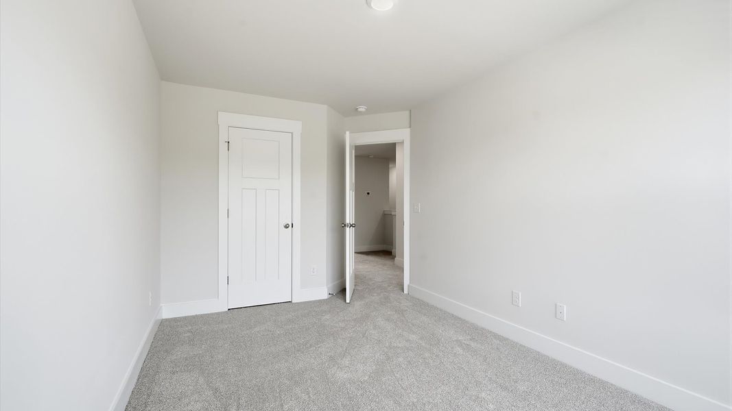 Tasteful secondary bedroom with plush carpet and a spacious walk-in closet near Downtown Greenville Tasteful secondary bedroom with plush carpet and a spacious walk-in closet near Downtown Greenville