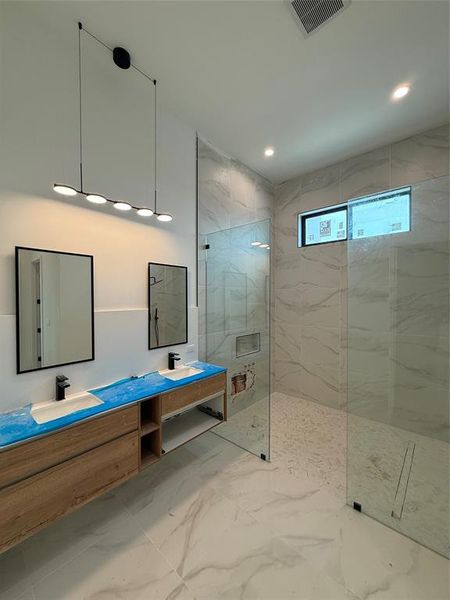 Bathroom with marble finish floors, double vanity, a marble finish shower, and recessed lighting Bathroom with marble finish floors, double vanity, a marble finish shower, and recessed lighting