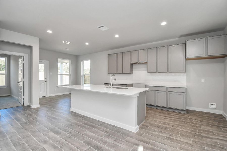 Experience the epitome of a dream kitchen in this generously spacious layout! Revel in features like a massive granite island, high ceilings, soft-close cabinets, granite countertops, stainless steel appliances, a sleek tile backsplash, and recessed lighting. With an open concept design, this kitchen seamlessly connects to the expansive family room, creating a perfect and inviting hub for gatherings. Sample photo of completed home with similar floor plan. Actual colors and selections may vary. Experience the epitome of a dream kitchen in this generously spacious layout! Revel in features like a massive granite island, high ceilings, soft-close cabinets, granite countertops, stainless steel appliances, a sleek tile backsplash, and recessed lighting. With an open concept design, this kitchen seamlessly connects to the expansive family room, creating a perfect and inviting hub for gatherings. Sample photo of completed home with similar floor plan. Actual colors and selections may vary.