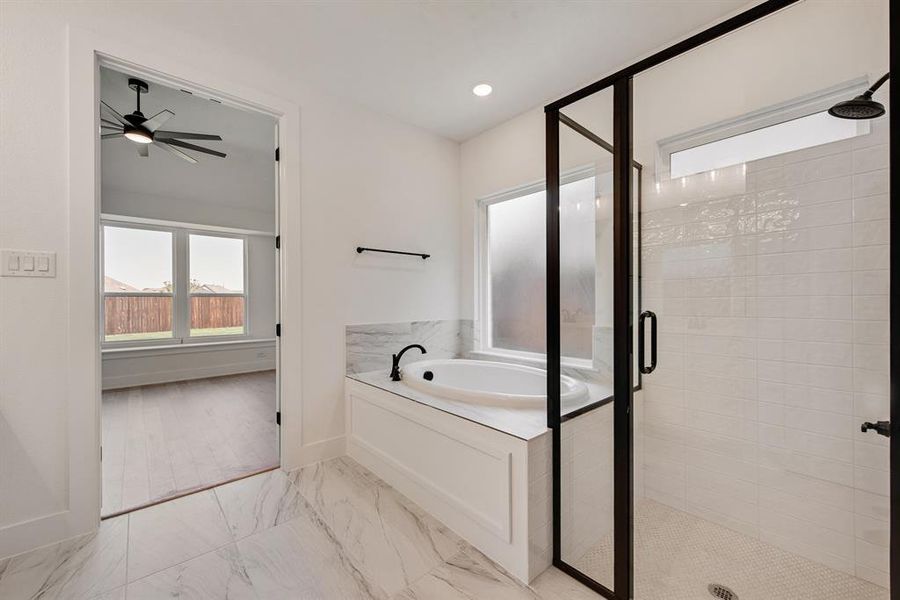 Full bathroom with a shower stall, a bath, light marble finish flooring, a ceiling fan, and recessed lighting Full bathroom with a shower stall, a bath, light marble finish flooring, a ceiling fan, and recessed lighting