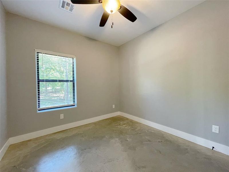 Unfurnished room with concrete flooring and ceiling fan