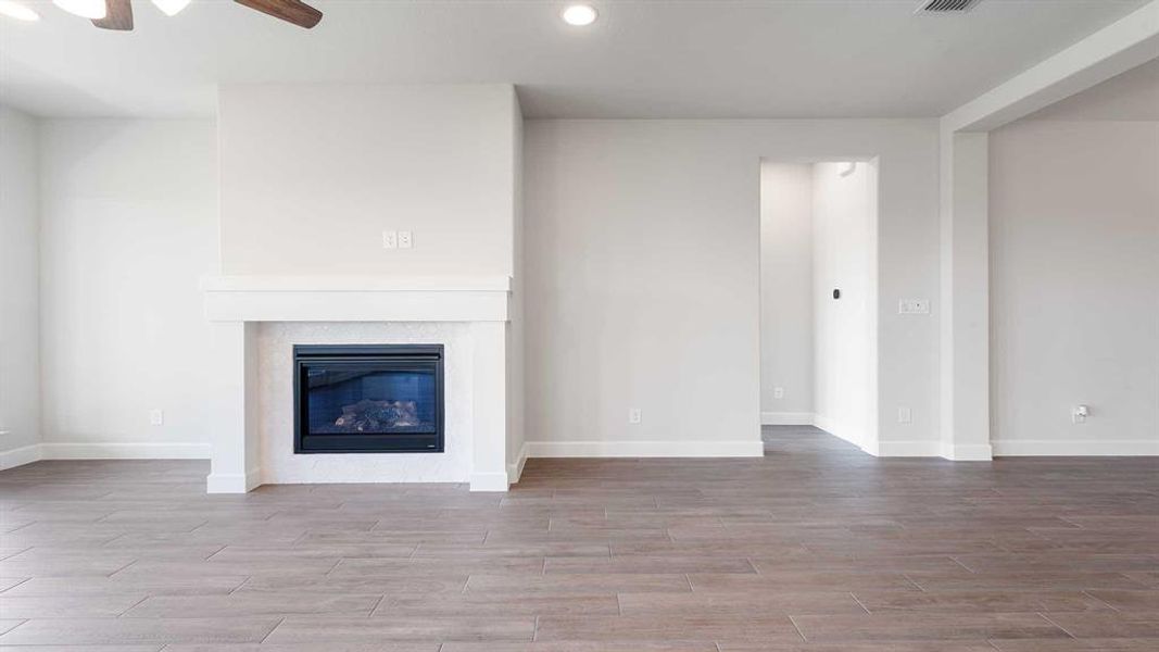 Unfurnished living room with light wood-type flooring and ceiling fan