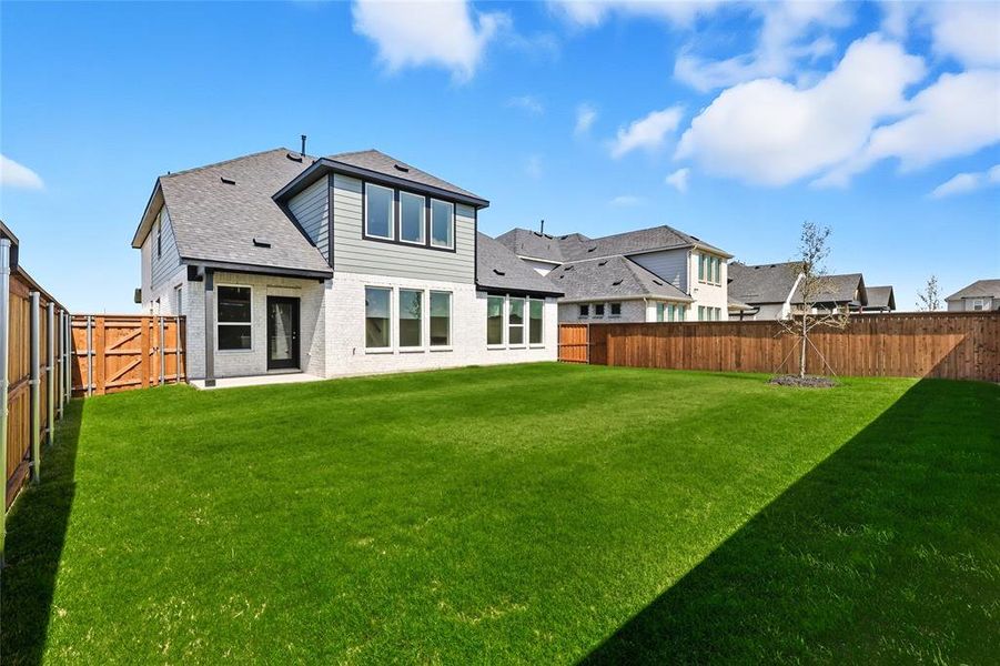 Back of house featuring a fenced backyard, brick siding, and roof with shingles Back of house featuring a fenced backyard, brick siding, and roof with shingles