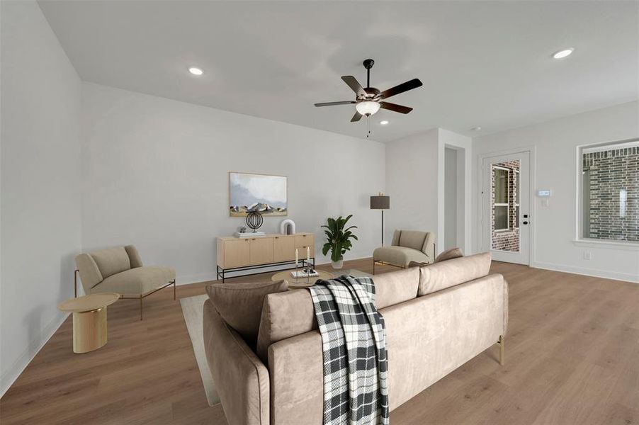 Spacious living area featuring wood-finish flooring, recessed lighting, and a ceiling fan Spacious living area featuring wood-finish flooring, recessed lighting, and a ceiling fan