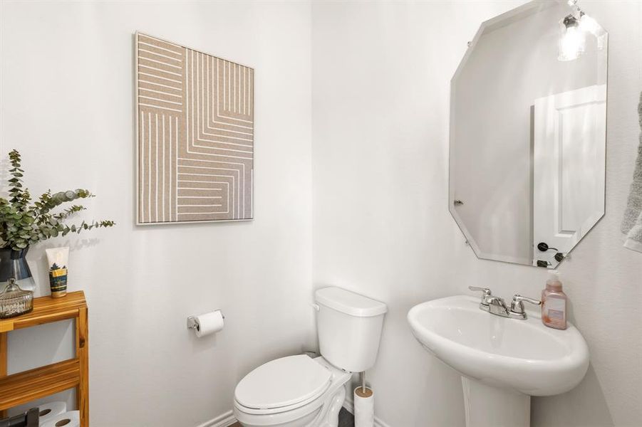 This bathroom features a pedestal sink with a chrome faucet, and an octagonal mirror This bathroom features a pedestal sink with a chrome faucet, and an octagonal mirror