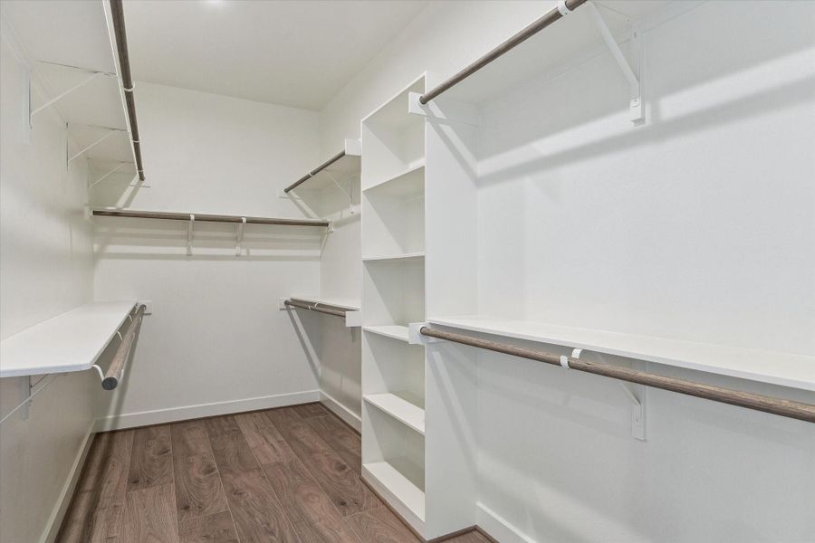 A generous walk-in closet offers built-in shelving and abundant hanging space, keeping wardrobes organized and easily accessible.