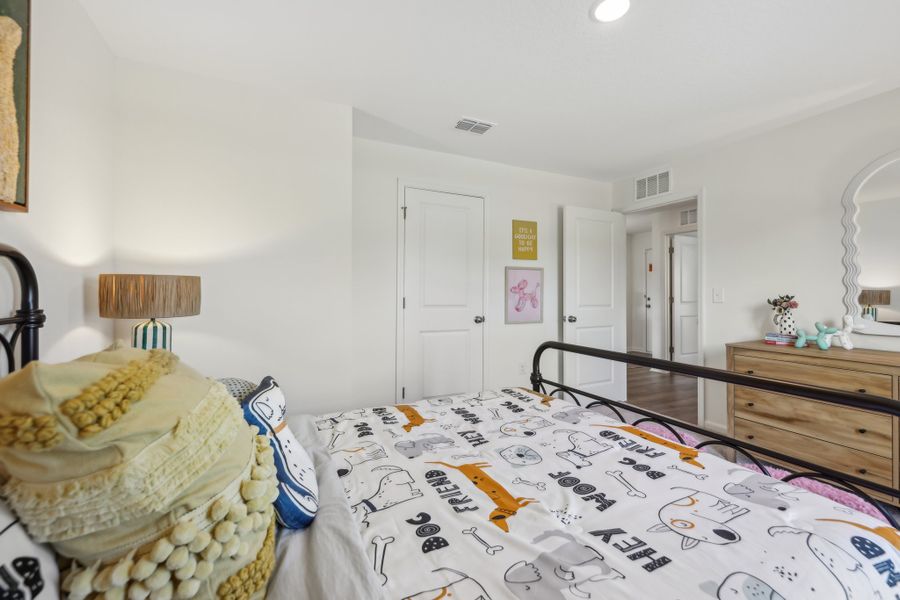 A bedroom with a bed and a lamp.