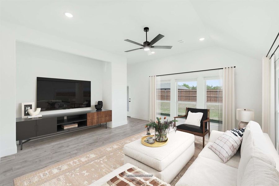 Living room with light wood floors, ceiling fan, wall-mounted TV, and large windows with backyard view Living room with light wood floors, ceiling fan, wall-mounted TV, and large windows with backyard view