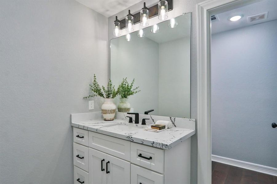 A Versatile Floorplan and Layout. This full sized guest bathroom on the first level features Quartz countertops, custom solid wood cabinets, upscale fixtures and more.