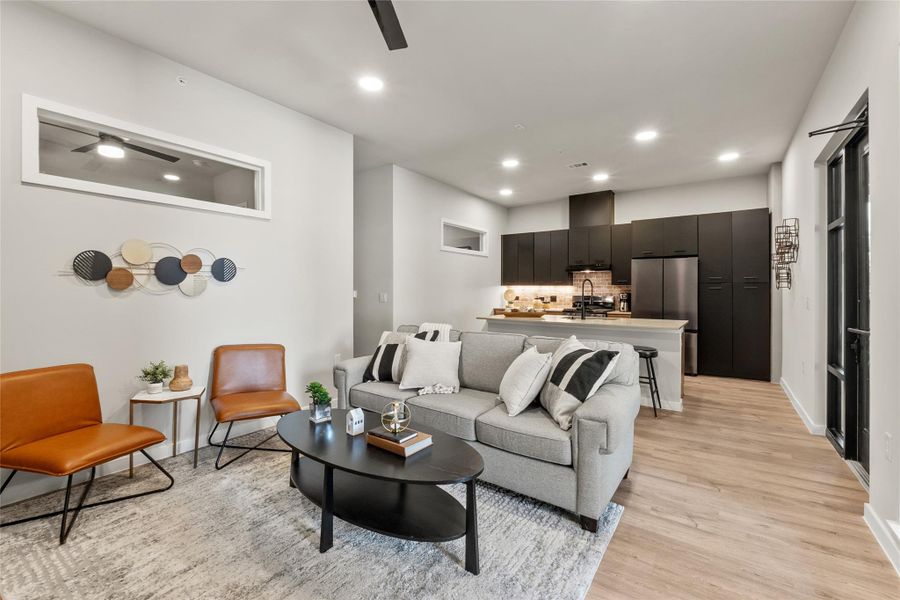 Living area with ceiling fan, light wood-style floors, and recessed lighting