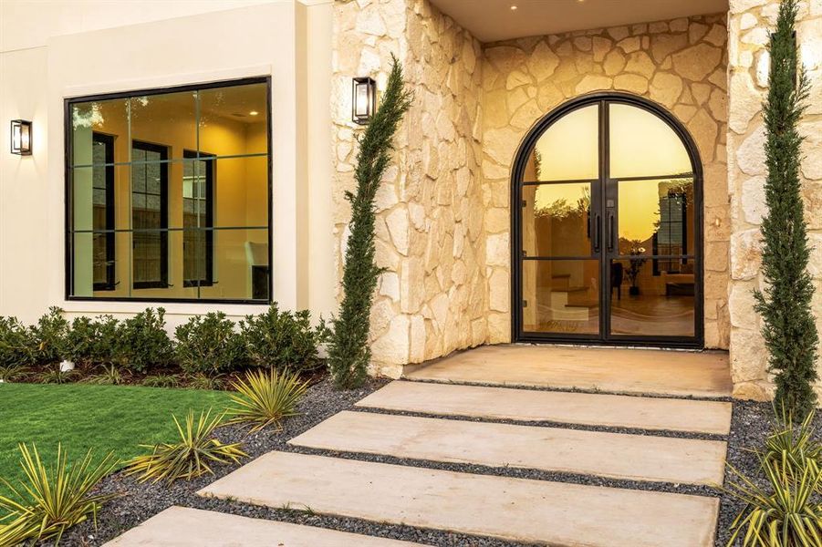 Property entrance with stone siding, stucco siding, and french doors Property entrance with stone siding, stucco siding, and french doors