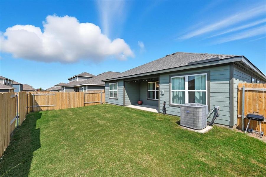 Rear view of property featuring a fenced backyard, a patio area, and roof with shingles