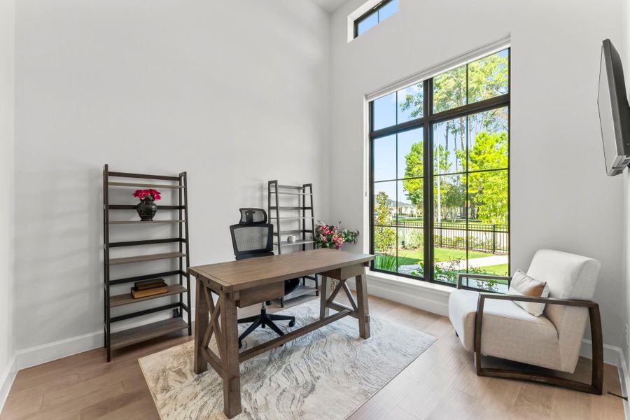 This image provides a different perspective of the office, showing more of the room's depth. The large window is prominent. This image provides a different perspective of the office, showing more of the room's depth. The large window is prominent.