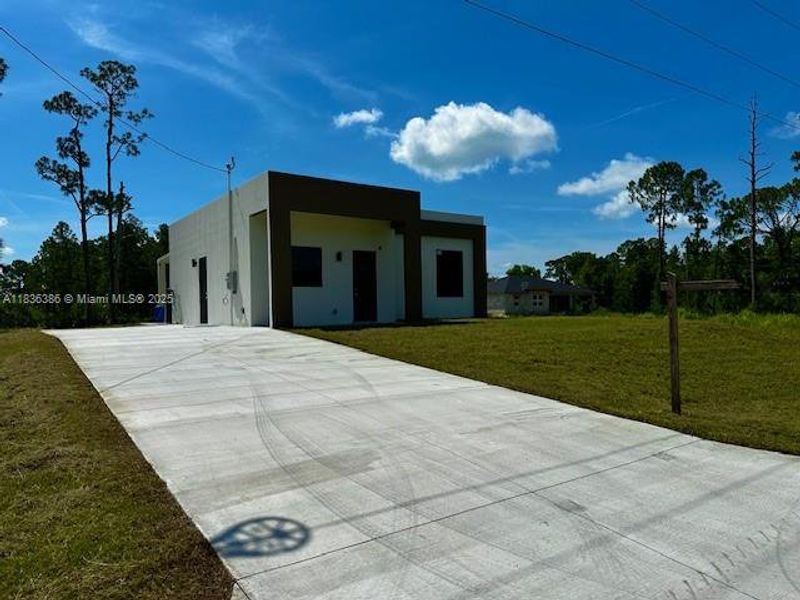 Front exterior of a new home in , Lehigh Acres, FL, highlighting curb appeal (Image 7).