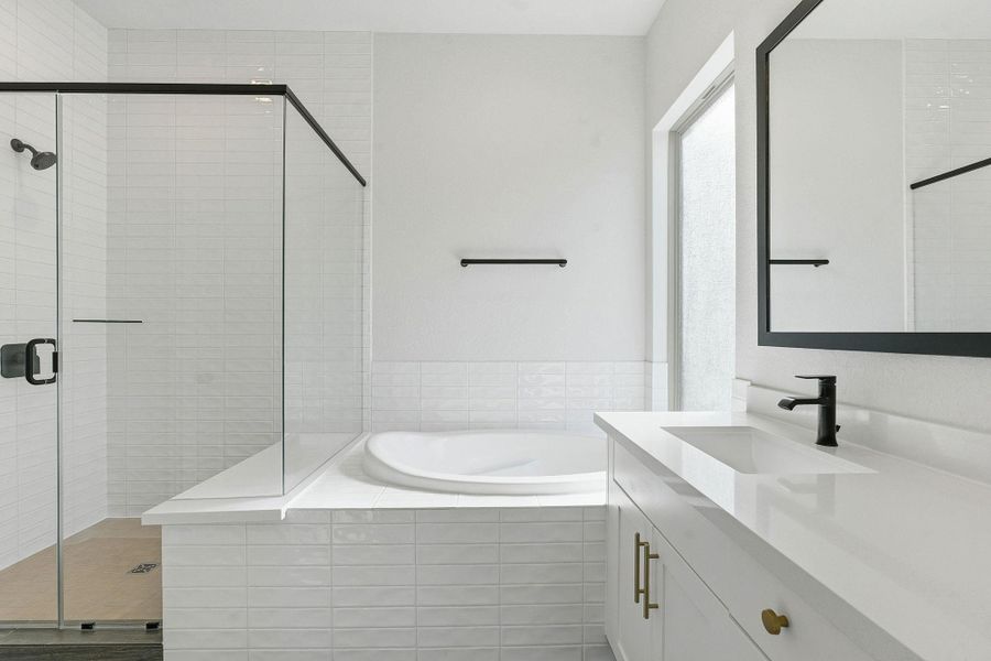 Full bath with vanity, a stall shower, and a bath