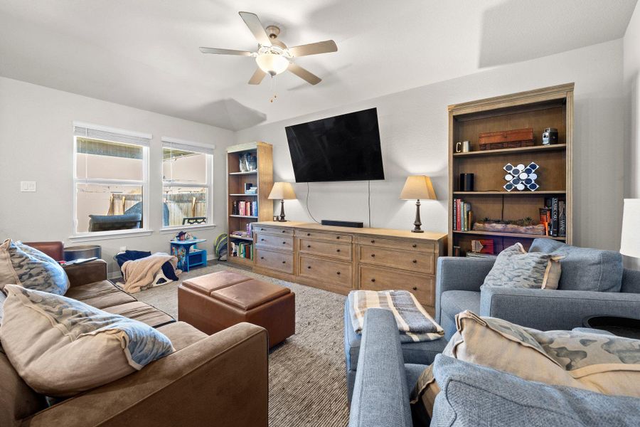 Living room featuring ceiling fan and carpet Living room featuring ceiling fan and carpet