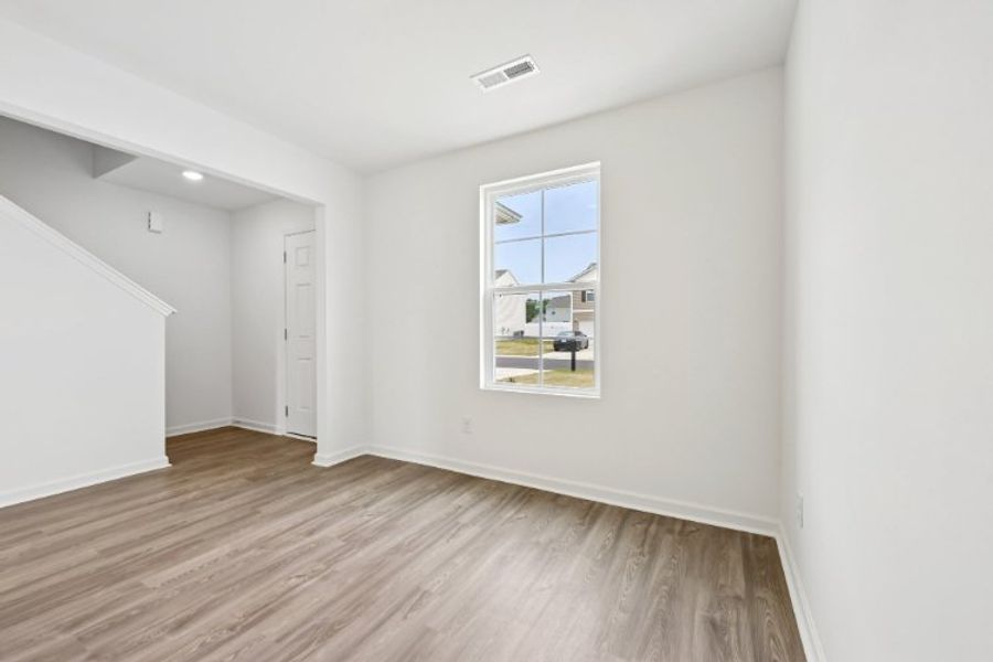 A room with a wood floor and a window. A room with a wood floor and a window.