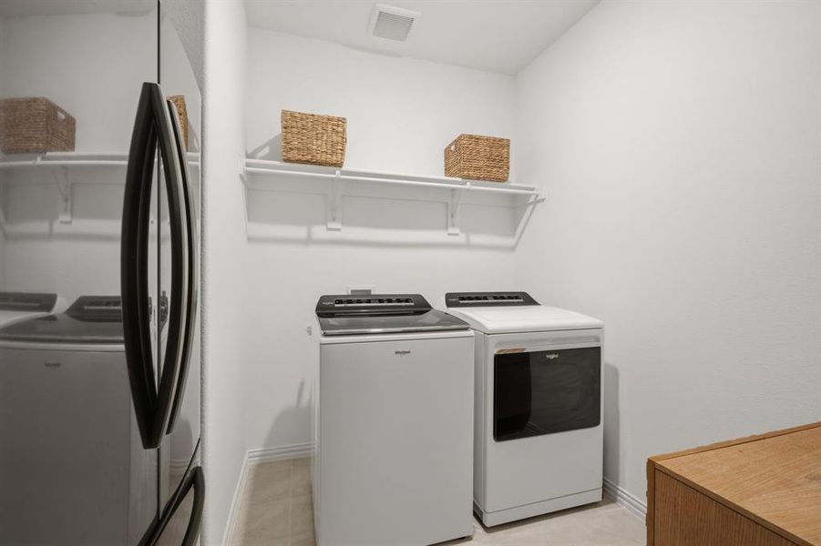 Spacious laundry room with room for full-size appliances, shelving, and extra storage. Practical, clean, and move-in ready.