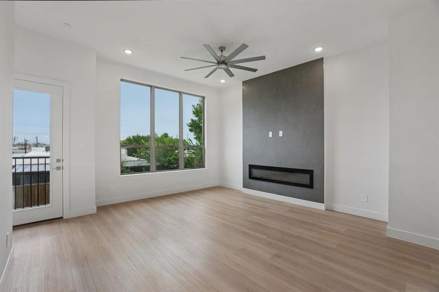 Unfurnished living room featuring a fireplace, light wood-style flooring, recessed lighting, and a ceiling fan