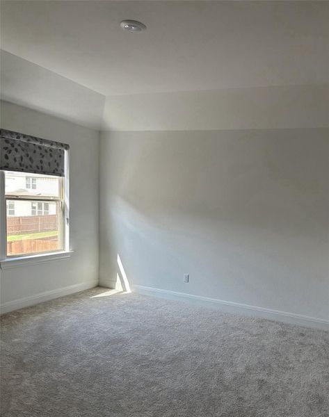Spacious room featuring vaulted ceilings, recessed lighting, neutral wall tones, and plush carpeting Spacious room featuring vaulted ceilings, recessed lighting, neutral wall tones, and plush carpeting