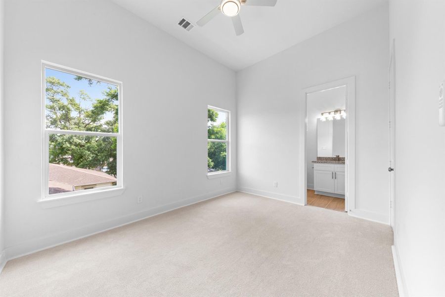 Secondary bedroom with neutral tones, ample closet space, and a comfortable layout.