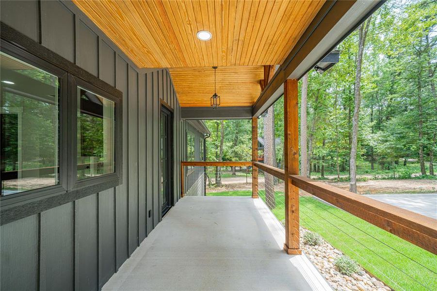 Expansive covered porch featuring a wood-plank ceiling with recessed lighting and a hanging lantern fixture