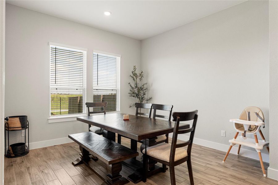 A welcoming dining area offers warm wood flooring and ample natural light through well-appointed windows. A welcoming dining area offers warm wood flooring and ample natural light through well-appointed windows.