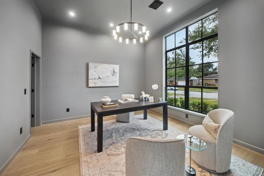 This private study, located at the front of the home, features floor-to-ceiling windows, recessed lighting, and plenty of space for productivity or relaxation.