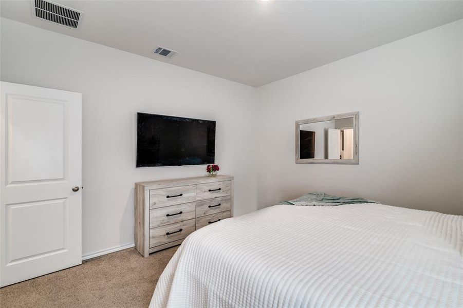 Bedroom with visible vents and light colored carpet