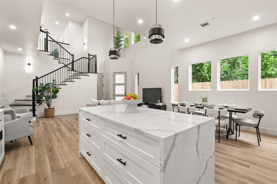 The island anchors it all — kitchen, dining, and living connected in one open space The island anchors it all — kitchen, dining, and living connected in one open space