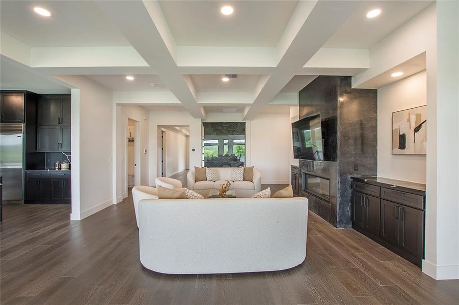 Living room with beam ceiling, a fireplace, coffered ceiling, and dark hardwood / wood-style flooring