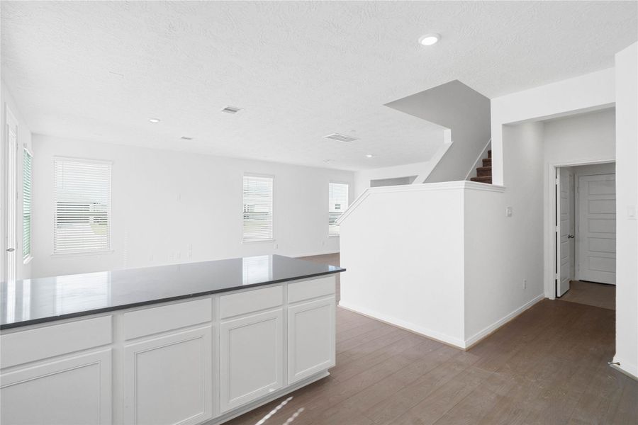 Additional view from kitchen looking towards hallway to laundry room, powder room, and staircase to second floor.