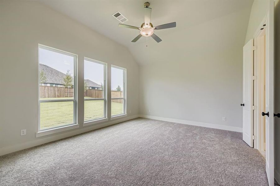 Spare room with light colored carpet, vaulted ceiling, and ceiling fan