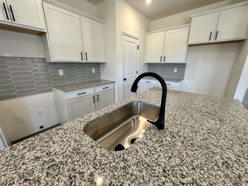 Kitchen featuring granite counters, white cabinetry, and decorative beautiful backsplash Kitchen featuring granite counters, white cabinetry, and decorative beautiful backsplash