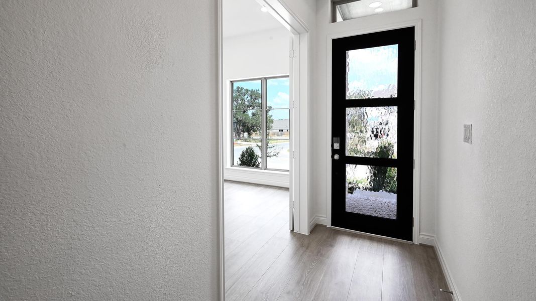 Entrance foyer featuring a textured wall and wood finished floors Entrance foyer featuring a textured wall and wood finished floors