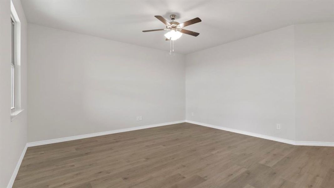 Empty room with a ceiling fan and dark wood-style floors