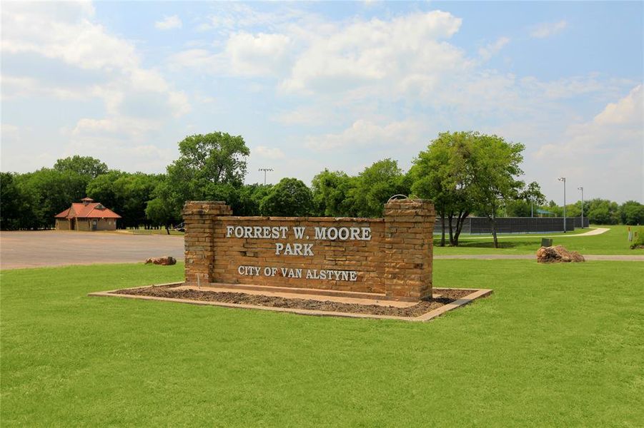 Community / neighborhood sign featuring a yard