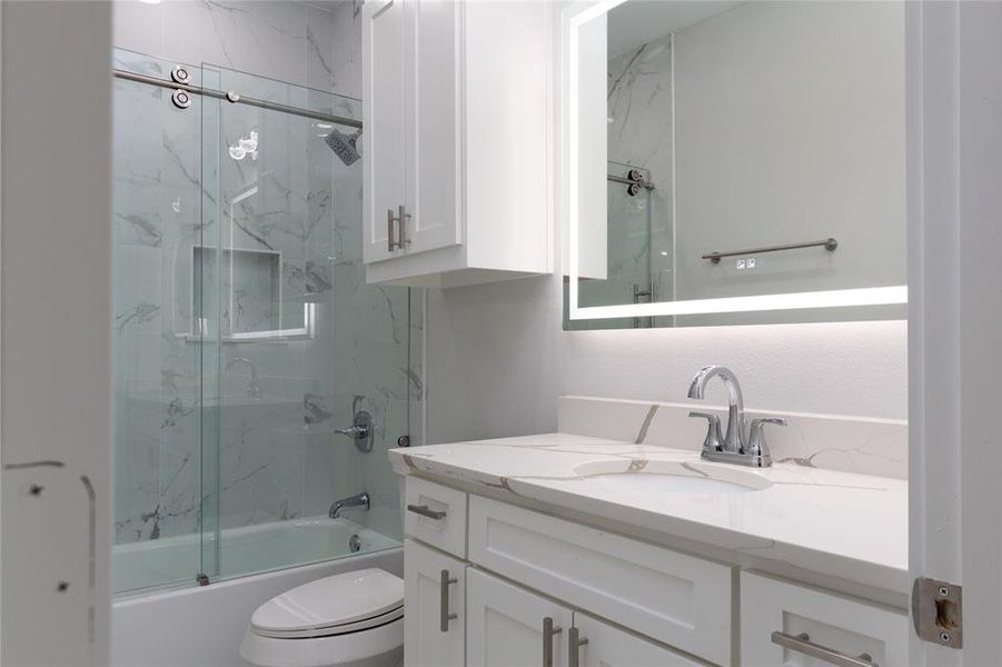Full bathroom with bath / shower combo with glass door and vanity
