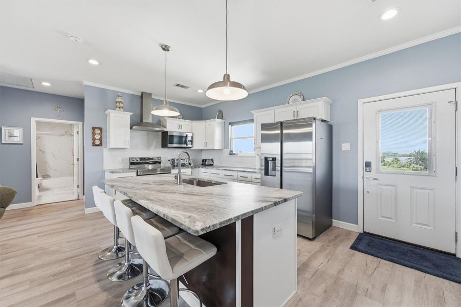 Modern kitchen with sleek stainless steel appliances, a spacious island with seating offering a bright and inviting space for cooking and entertaining. Modern kitchen with sleek stainless steel appliances, a spacious island with seating offering a bright and inviting space for cooking and entertaining.