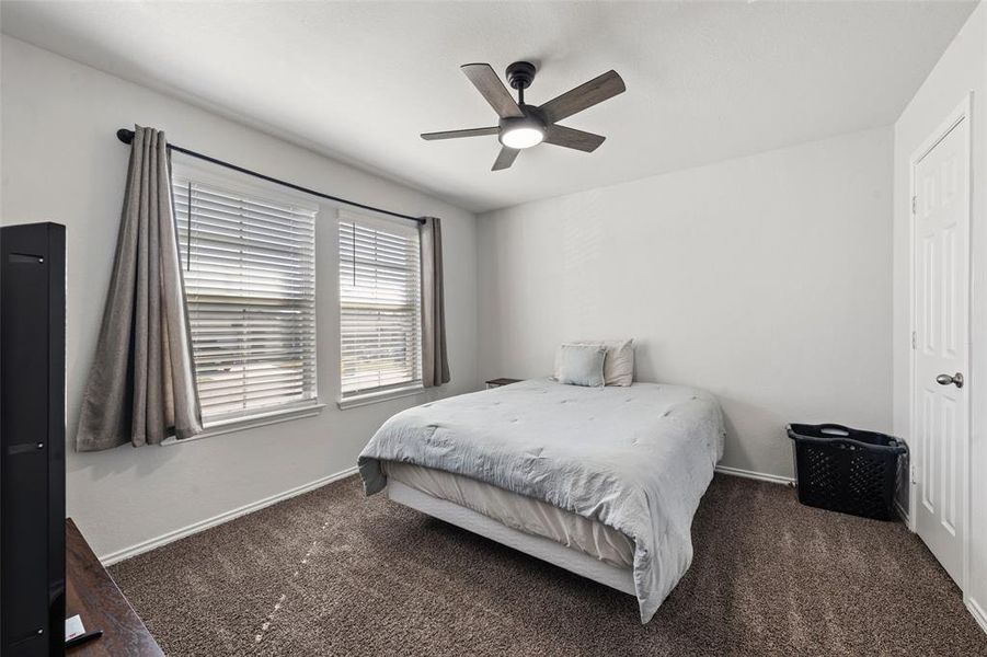 Bedroom with dark colored carpet and ceiling fan